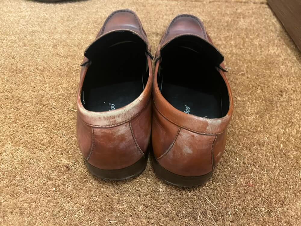 手入れされていない色落ちした茶色の革靴