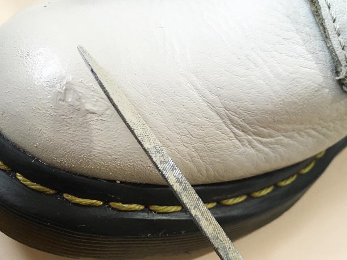 傷がひどい革靴の窪みに埋めていた補修クリームをヤスリで削る
