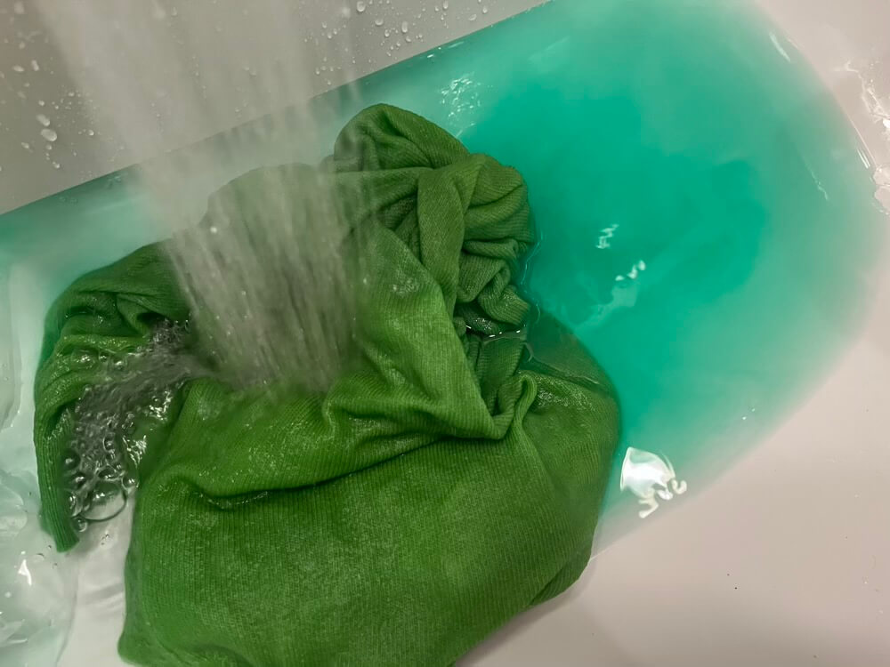 洗面台でせーたーをすすいでいる様子