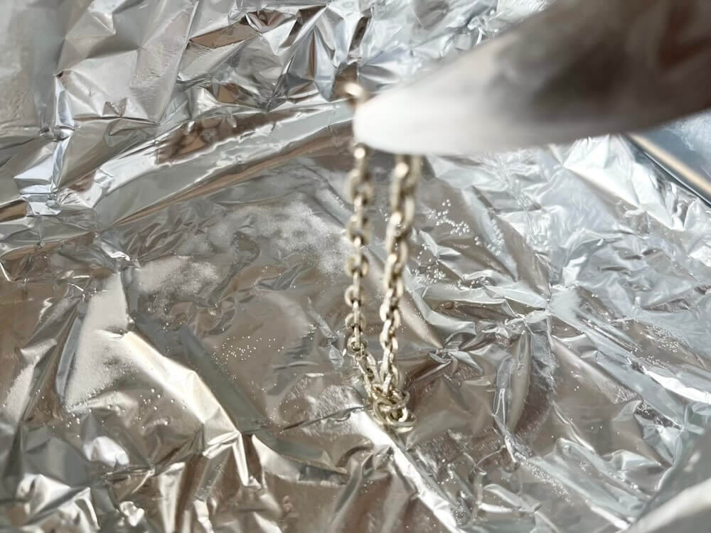 シルバーアクセサリーを、容器から取り出す様子