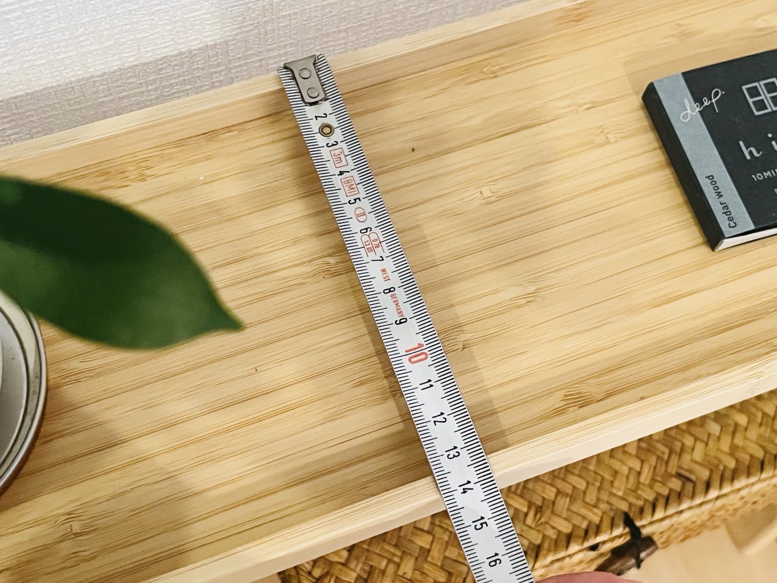 無印良品の竹材スリムトレーテーブルの奥行きを測っている様子